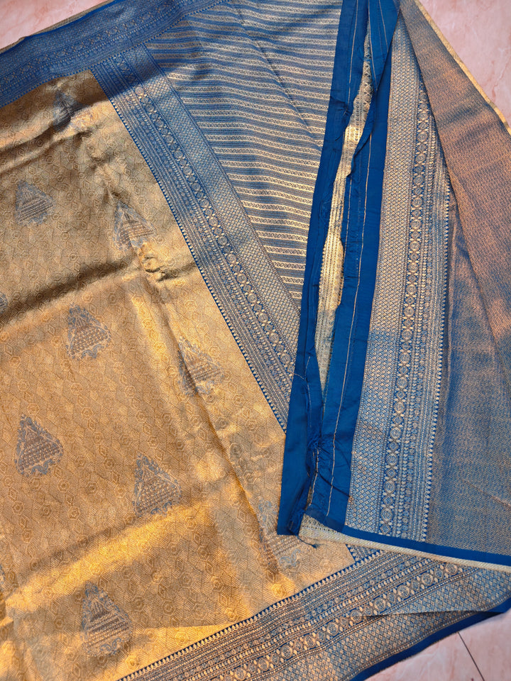 DHARMAVARAM ALFI IN GOLD WITH MEENA BOOTA AND BLUE BORDER